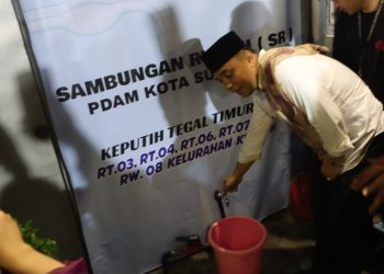 Wali Kota Surabaya Eri Cahyadi memutar kran tanda beralihnya master meter ke sambungan rumah pada syukuran di Keputih Tegal Baru.
