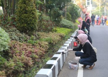 Pengecatan ulang pada curbing median jalan menyambut HJKS ke-731 yang dilakukan pegawai Pemkot Surabaya