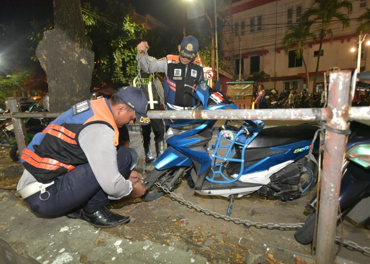 Personel Dishub Surabaya melakukan penggembokan terhadap kendaraan yang kedapatan parkir di bawah rambu larangan, maupun di tepi jalan di kawasan Kota Lama Surabaya.