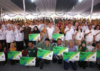 Penyerahan kartu BPJS Ketenagakerjaan kepada perwakilan warga pelayan masyarakat di halaman Balai Kota Surabaya.