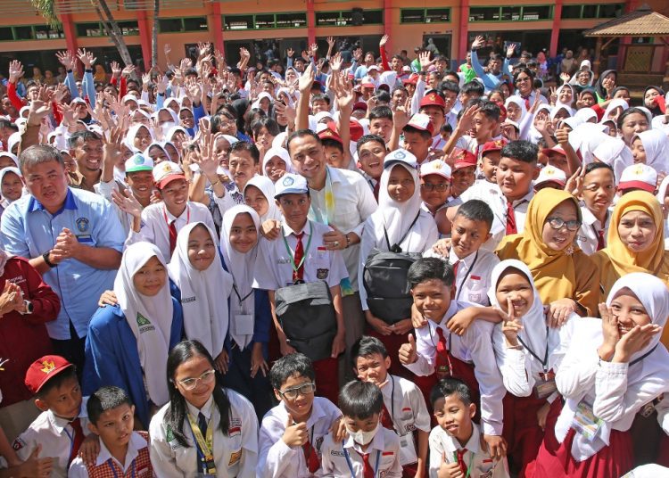 Wali Kota Surabaya Eri Cahyadi dalam salah satu kunjungannya ke sekolah dasar negeri untuk menyerahkan seragam dan perlengkapan sekolah kepada siswa.
