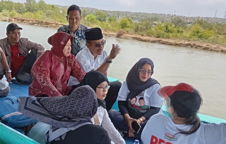 Tri Rismaharini menumpangi perahu saat meninjau meninjau lokasi titik banjir di Kabupaten Sampang.