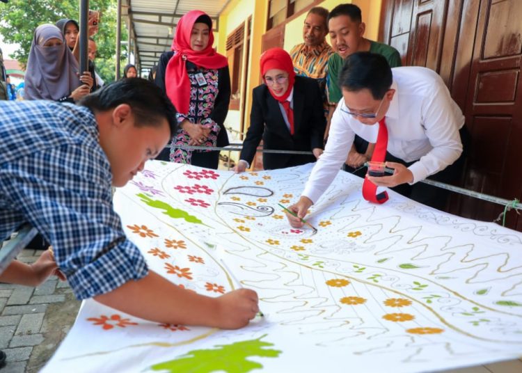 Pj Gubernur Jatim Adhy Karyono ikut menggambar motif batik tulis karya anak-anak disabilitas di Blitar.
