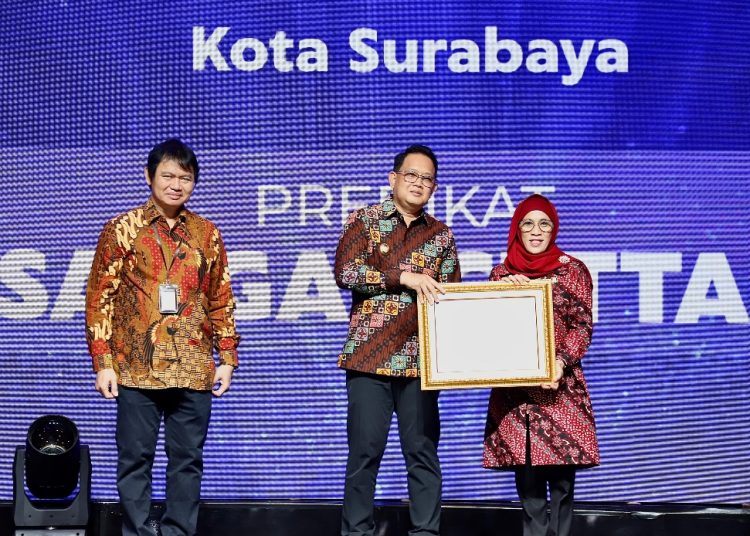 Pj Gubernur Jatim Adhy Karyono menyerahkan penghargaan kepada Pjs Wali Kota Surabaya, Restu Novi Widiani.