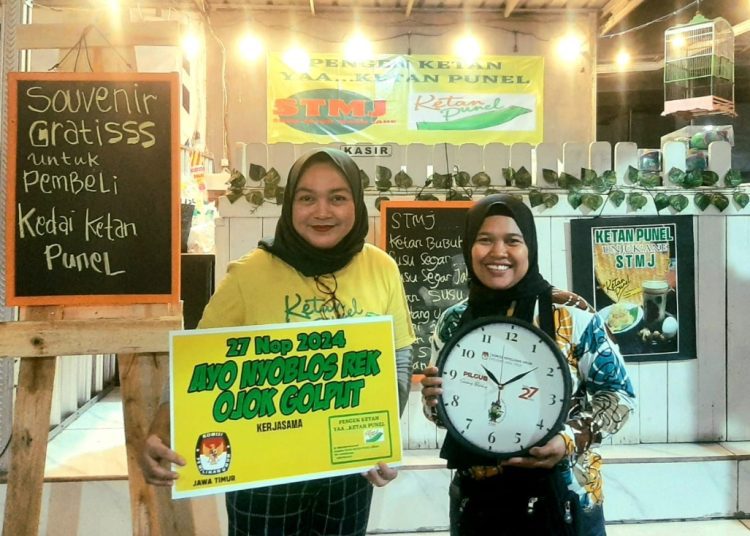 Salah satu pembeli Kedai Ketan Punel mendapatkan suvenir dari KPU Jatim.