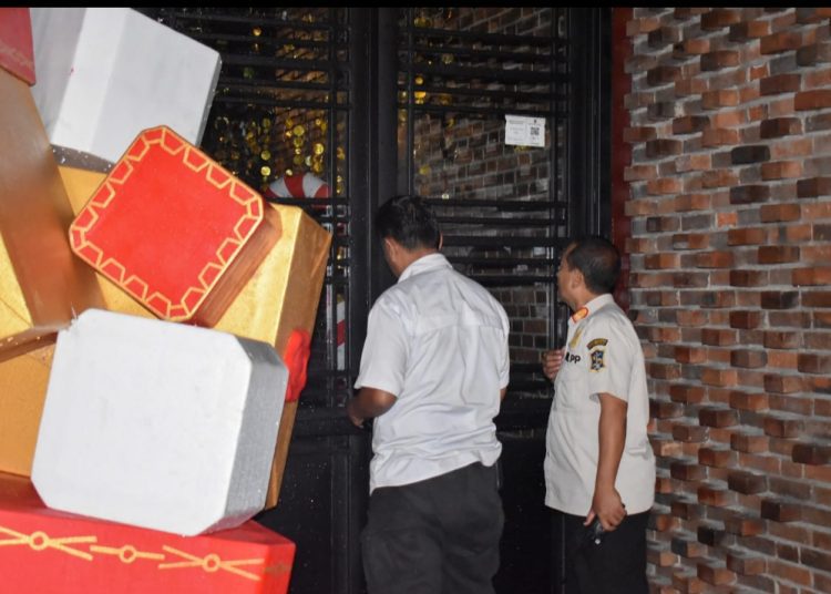 Personel Satpol PP mengecek pintu masuk RHU untuk memastikan apakah RHU tersebut beroperasional atau tidak.
