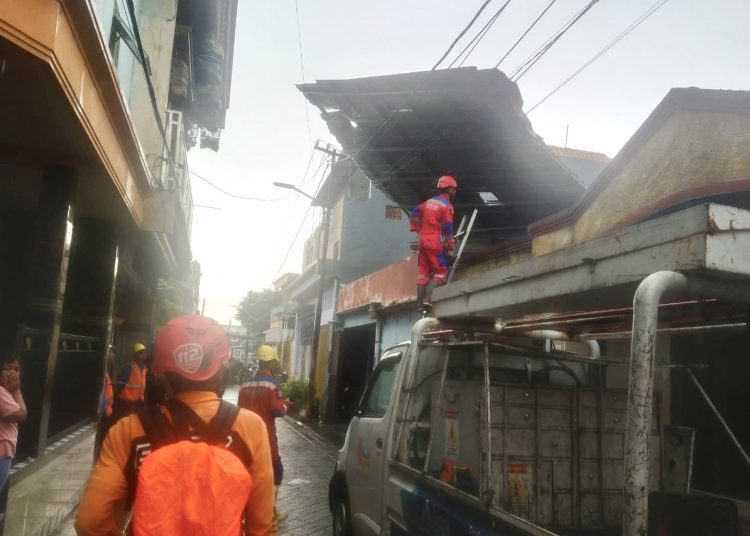 Penanganan salah satu rumah yang atapnya terimbas angin kencang.