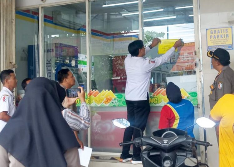 Pemasangan stiker tanda bangunan sudah berizin di toko modern berjejaring di Bojonegoro.