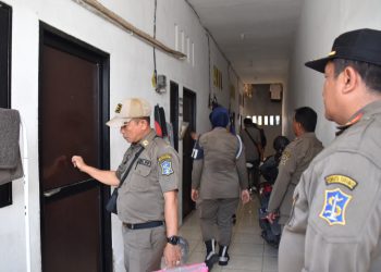 Para personel Satpol PP Surabaya mengetuk pintu kamar dalam operasi yustisi di salah satu rumah kos di kawasan Tambakwedi.