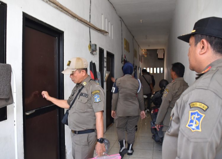 Para personel Satpol PP Surabaya mengetuk pintu kamar dalam operasi yustisi di salah satu rumah kos di kawasan Tambakwedi.