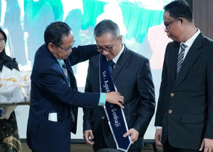 Kepala Departemen Teknik Sistem dan Industri ITS Prof Dr Ir Mokh Suef MScEng ketika menyandangkan gelar doktor kepada Dr Agus Imam Sonhaji ST MMT.
