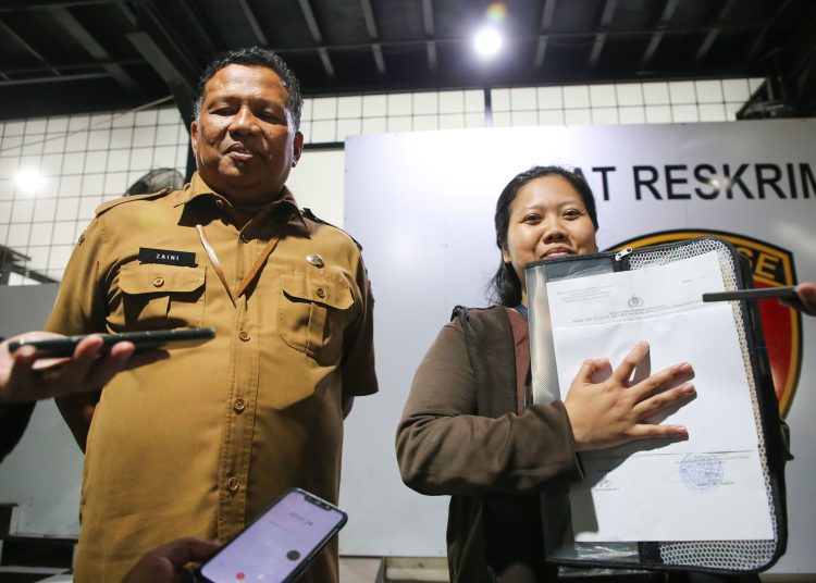 Kepala Dinas Perindustrian dan Tenaga Kerja Surabaya, Achmad Zaini mendampingi Nila Handiarti melapor ke Polres Pelabuhan Tanjung Perak, Surabaya.