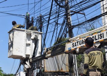 Penertiban kabel utilitas oleh personel Satpol PP Surabaya.