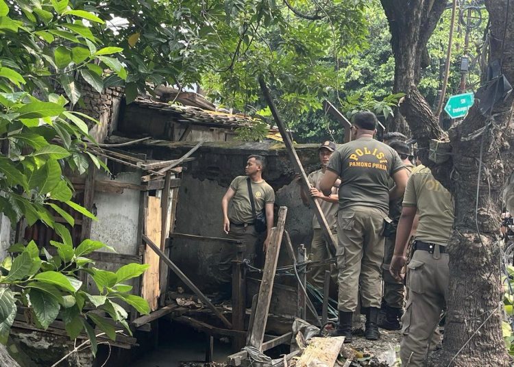 Foto dokumentasi kegiatan Satpol PP Surabaya melakukan penertiban bangunan yang berdiri di atas saluran air.