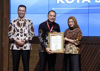 Menteri PAN-RB, Rini Widyantini menyerahkan penghargaan kepada Wali Kota Surabaya Eri Cahyadi.