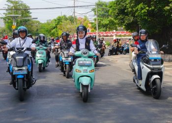 Gubernur Khofifah mengendarai motor listrik bersama iring-iringan defile menuju rumah para penerima manfaat.