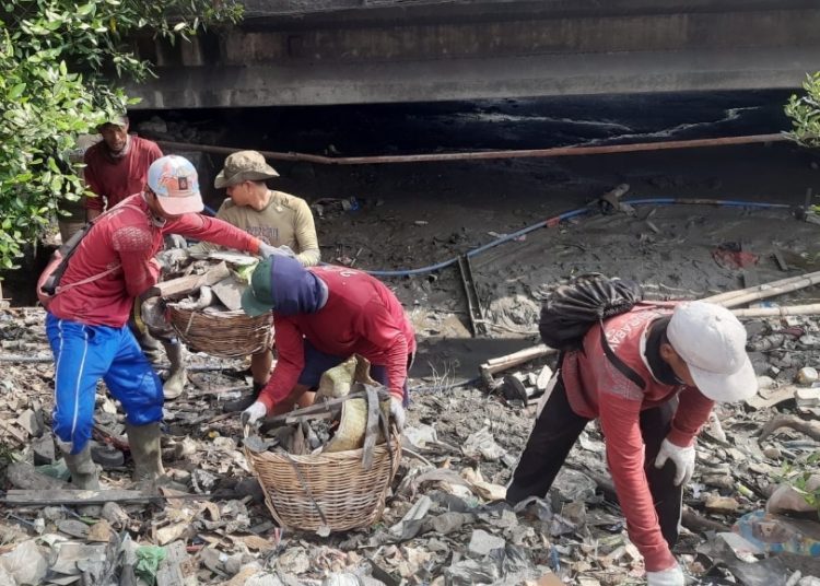 Tim satgas banjir melakukan pembersihan sampah di saluran air.