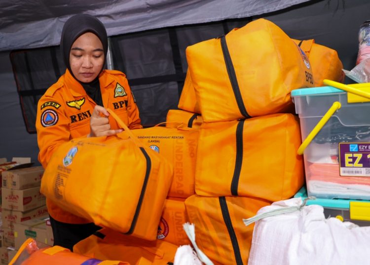 Personel BPBD Surabaya mengecek ulang bantuan kemanusiaan untuk bencana Sumatera di posko peduli di halaman Balai Kota.