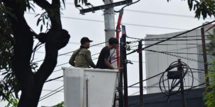 Tim Satpol PP Surabaya menertibkan utilitas fiber optik (FO) milik sejumlah penyedia layanan internet yang tidak berizin di kawasan Jalan Panjang Jiwo, Surabaya.