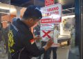 Petugas menyegel tempat usaha yang melanggar Surat Edaran (SE) Wali Kota Surabaya Nomor 300/2326/436.8.6/2026 tentang Pedoman Keamanan dan Ketertiban selama Bulan Suci Ramadan dan Hari Raya Idulfitri 2026.