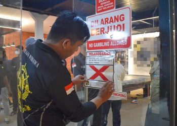 Petugas menyegel tempat usaha yang melanggar Surat Edaran (SE) Wali Kota Surabaya Nomor 300/2326/436.8.6/2026 tentang Pedoman Keamanan dan Ketertiban selama Bulan Suci Ramadan dan Hari Raya Idulfitri 2026.