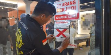 Petugas menyegel tempat usaha yang melanggar Surat Edaran (SE) Wali Kota Surabaya Nomor 300/2326/436.8.6/2026 tentang Pedoman Keamanan dan Ketertiban selama Bulan Suci Ramadan dan Hari Raya Idulfitri 2026.