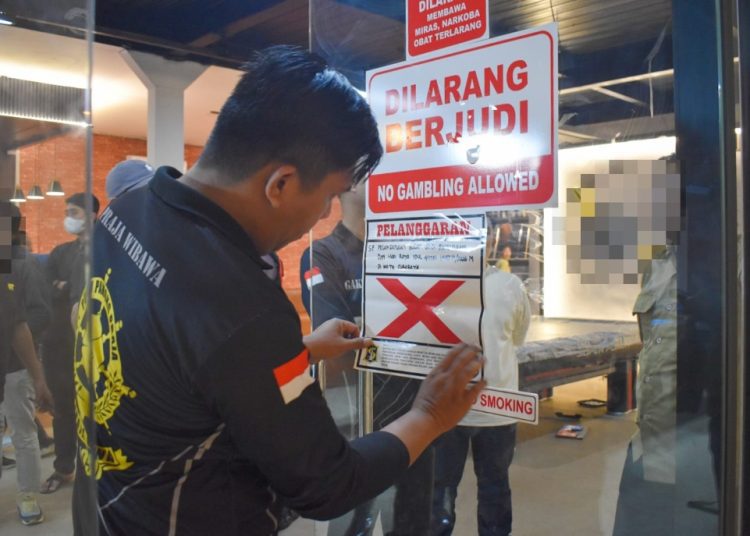 Petugas menyegel tempat usaha yang melanggar Surat Edaran (SE) Wali Kota Surabaya Nomor 300/2326/436.8.6/2026 tentang Pedoman Keamanan dan Ketertiban selama Bulan Suci Ramadan dan Hari Raya Idulfitri 2026.