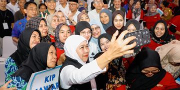 Gubernur Jawa Timur Khofifah Indar Parawansa  berswafoto di sela menyalurkan bantuan sosial dan tali asih senilai Rp 1,819 miliar untuk masyarakat Kota Kediri di Balai Kota Kediri.